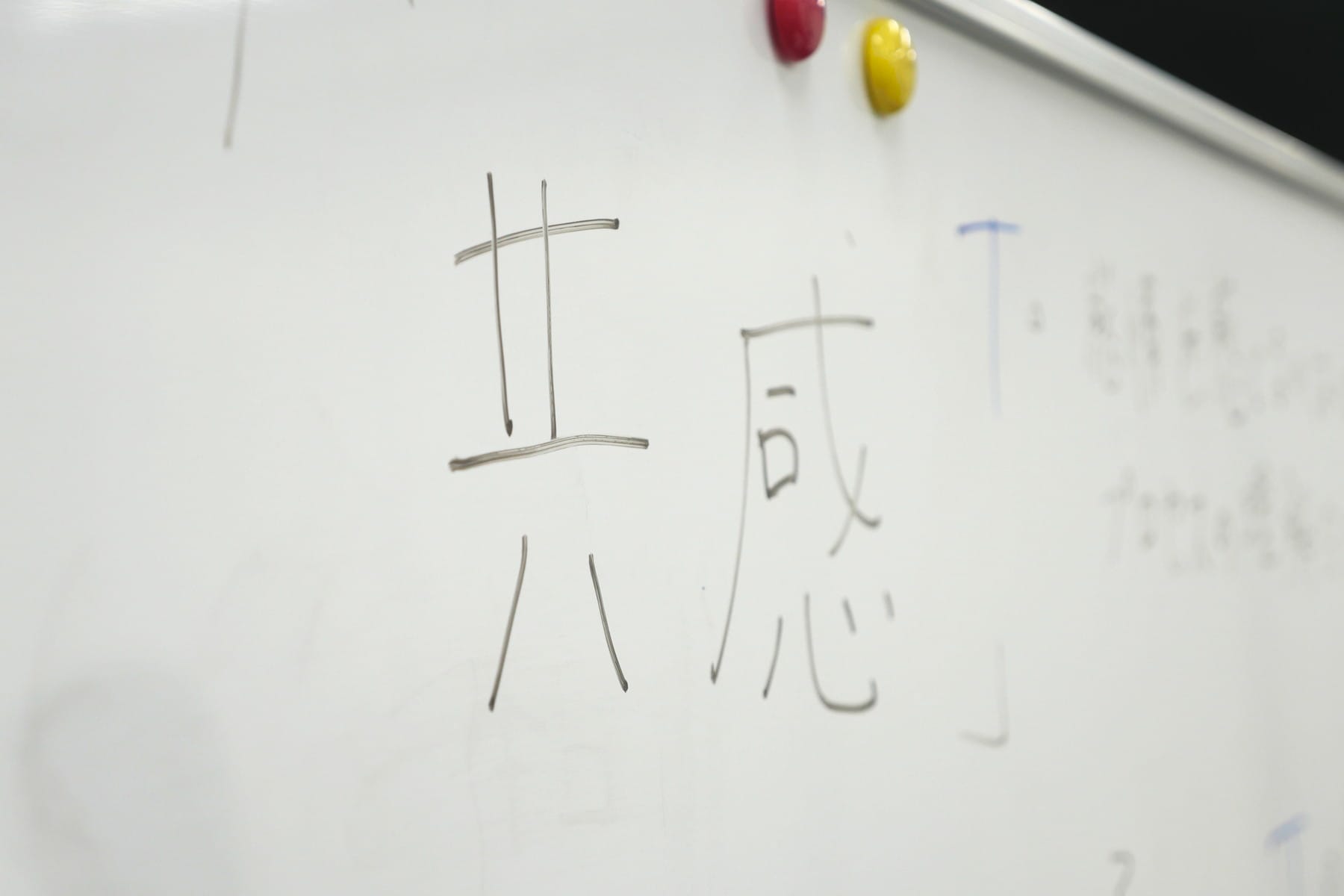 ホワイトボードに書かれた「共感」の文字